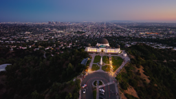 Griffith Observatory crowns the hills above a glittering Los Angeles skyline at dusk.