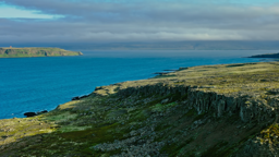 Rugged coastal cliffs sweep along Iceland's remote Westfjords peninsula beneath a dramatic Arctic sky.