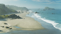 Misty sea stacks rise from turquoise waters along Oregon's rugged southern coastline.